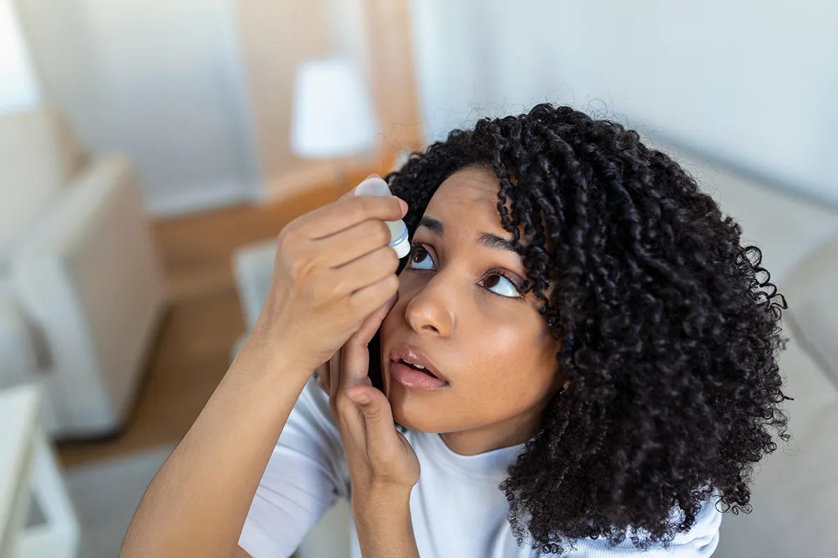 a woman putting in eye drops for dry eyes