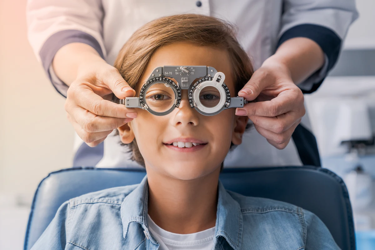 smiling child boy during eye exam at optometrist office